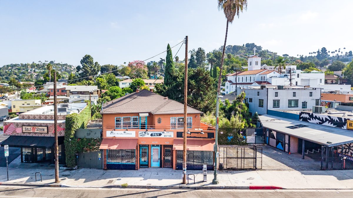 Elevated wide view of the terracotta building in its block, with Salt & Straw to the left and neighboring commercial buildings to the right.