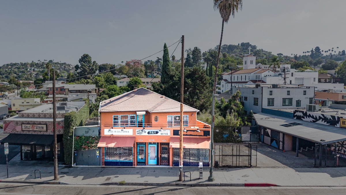 Elevated view with a white outline around the entire terracotta building, shown only as neighborhood context — not the available suite.
